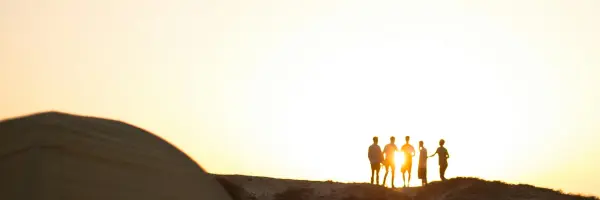 夕陽を背景に集う5人の若者たちの写真